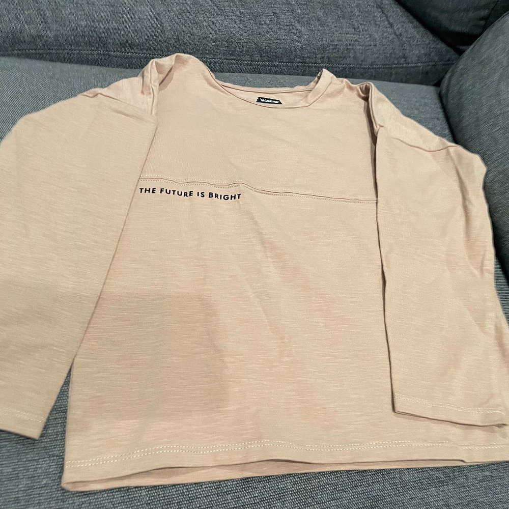 Tan long sleeved shirt that says "the future is bright."